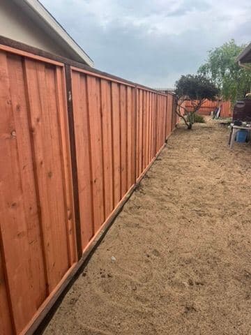Redwood privacy fence panel with dark stained posts and rails