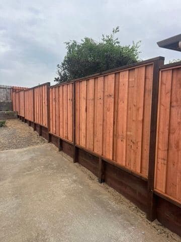 Finished redwood privacy fence raised on a kickboard